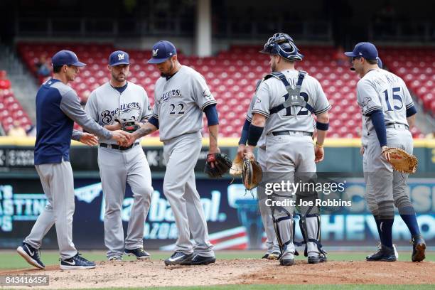 Matt Garza of the Milwaukee Brewers hands the ball to manager Craig Counsell as he is replaced in the third inning of a game against the Cincinnati...