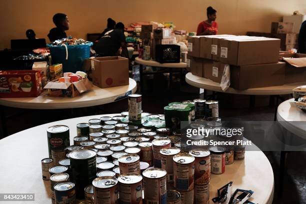 Cans of food are displayed on a table at a church that is now a relief center for flood victims in Orange as Texas slowly moves toward recovery from...