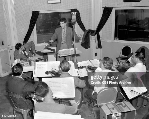 Campbell Playhouse radio production and rehearsal of The Hurricane directed by Orson Welles. At rear left, Orson Welles, director, seated with lunch,...