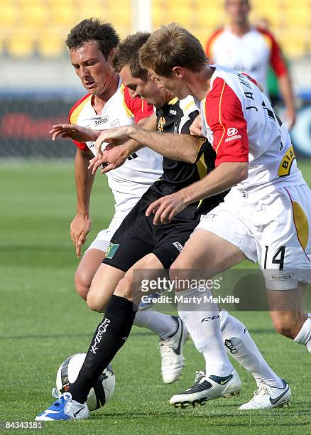 Shane Smeltz of the Phoenix gets tackled by Scott Jamieson and Fabian Barbiero of Adelaide during the round 20 A-League match between the Wellington...