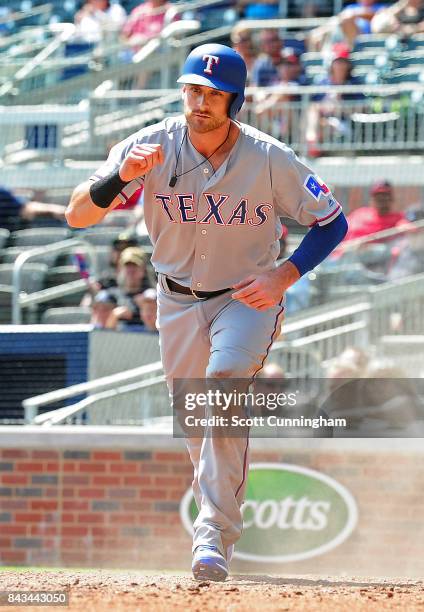 Will Middlebrooks of the Texas Rangers celebrates after scoring on a fourth inning wild pitch against the Atlanta Braves at SunTrust Park on...