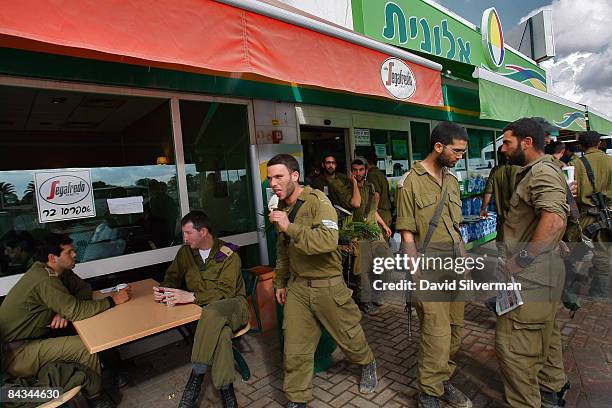 Israeli soldiers just deployed out of the Gaza Strip after fighting Hamas militants for nearly two weeks catch up on the news and get a bite to eat...