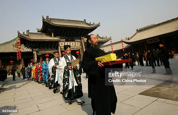 Taoist priests perform the ritual of making sacrifices to the kitchen god at a Town's God Temple on January 18, 2009 in Xian of Shaanxi Province,...