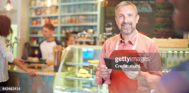 coffee shop owner checking his online accounts - online bank service stock pictures, royalty-free photos & images