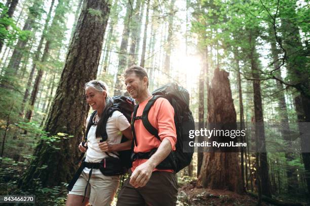 madura pareja backpacking en bosque - noroeste pacífico de los estados unidos fotografías e imágenes de stock