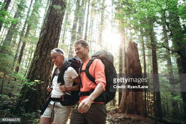 mature couple backpacking in forest - washington state stock pictures, royalty-free photos & images