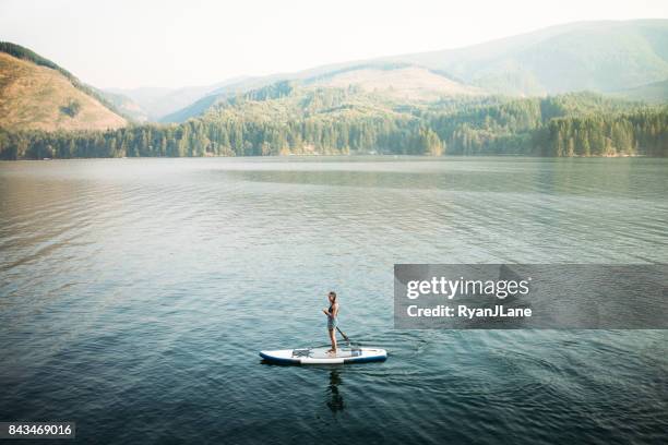 paddleboarding donna matura - paddle surf foto e immagini stock