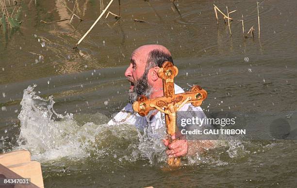 Christian Orthodox pilgrim immerses himself in the water of the Jordan River during the Epiphany celebrations in Kasser-el-Yahud on January 18, 2009....