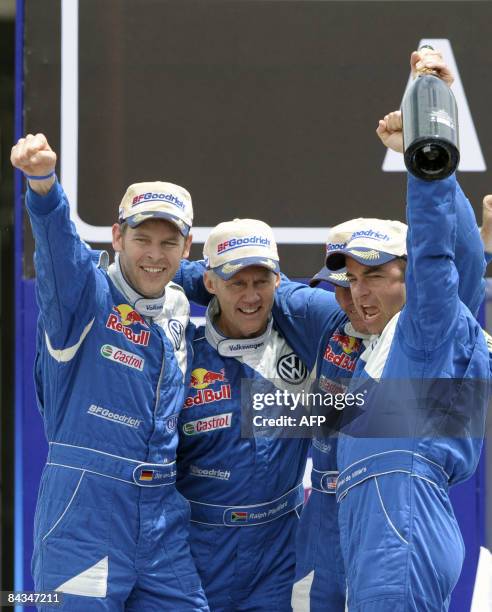 Volkswagen's Giniel De Villiers of South Africa and his co-driver Dirk Von Zitzewitz of Germany celebrate with the second place teammates driver Mark...