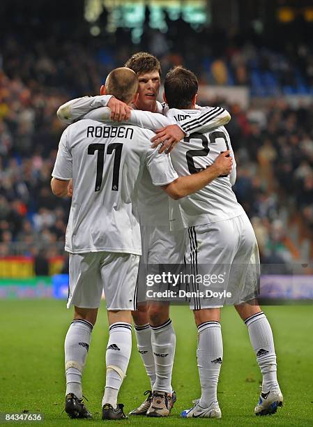 Arjen Robben of Real Madrid celebrates with Klaas Jan Huntelaar and Rafael Van Der Vaart after scoring Real's third goal against Osasuna during the...