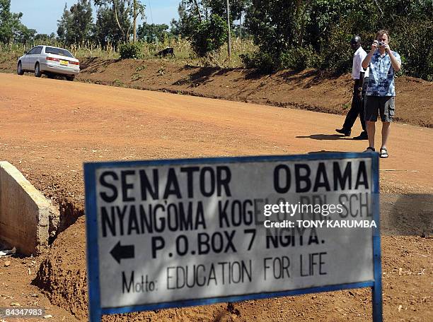 Photo taken January 13, 2009 shows a tourist at Nyang'oma, in Kogelo taking photos of a road sign of a school named after America's President elect,...