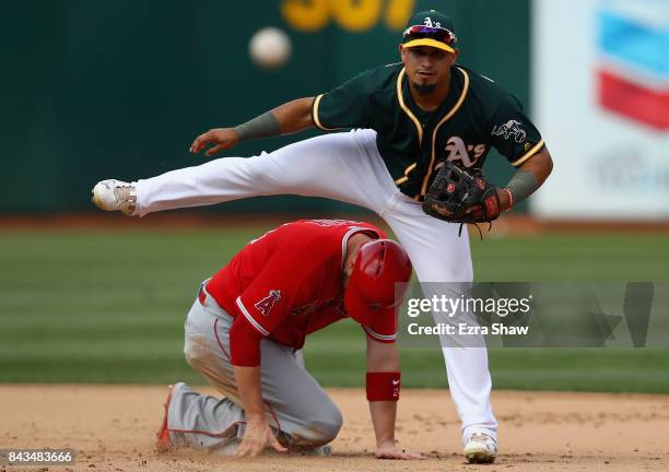 Franklin Barreto of the Oakland Athletics tries to turn a double play as C.J. Cron of the Los Angeles Angels slides in to second base on a ball hit...