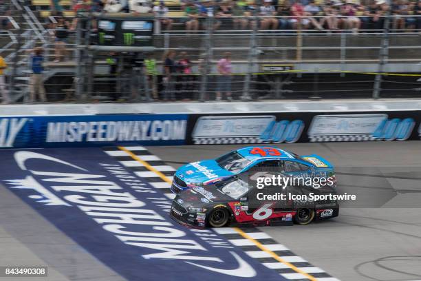 Trevor Bayne , driver of the Roush Performance Ford, and Aric Almirola , driver of the Smithfield Ford, race during the Monster Energy NASCAR Cup...