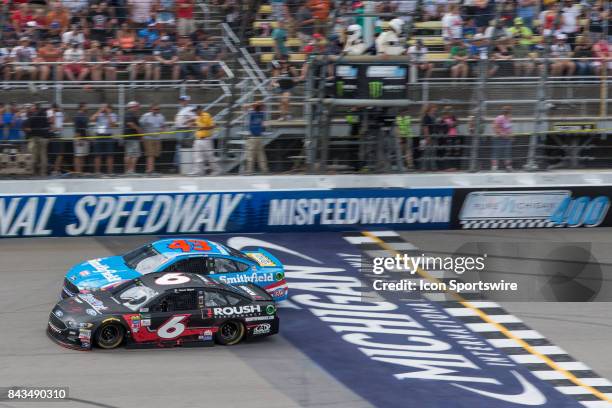 Trevor Bayne , driver of the Roush Performance Ford, and Aric Almirola , driver of the Smithfield Ford, race during the Monster Energy NASCAR Cup...