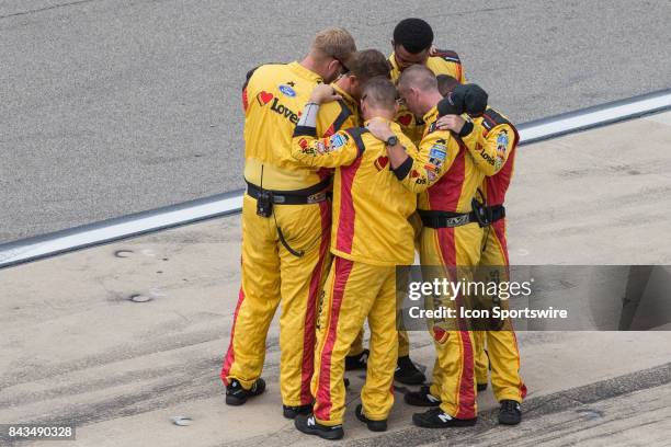 Crew members of Landon Cassill , driver of the MDS Transport Ford, team huddle together prior to the start of the Monster Energy NASCAR Cup Series -...