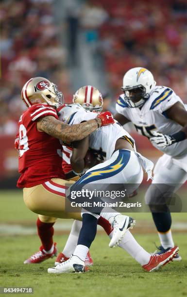 Aaron Lynch of the San Francisco 49ers tackles Kenjon Barner of the Los Angeles Chargers during the game at Levi's Stadium on August 31, 2017 in...