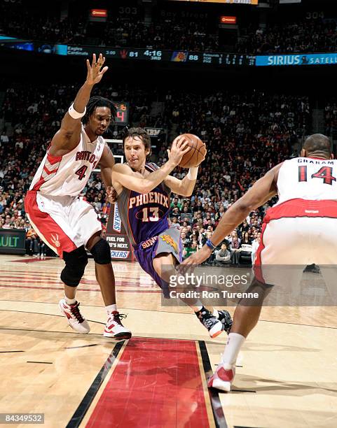 Steve Nash of the Phoenix Suns cuts through the lane defended by Chris Bosh of the Toronto Raptors on January 18, 2009 at the Air Canada Centre in...