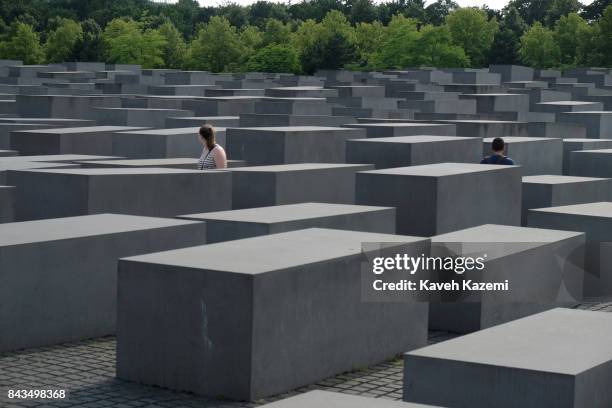 People walk amid concrete slabs or "stelae" in The Memorial to the Murdered Jews of Europe, also known as the Holocaust Memorial designed by...