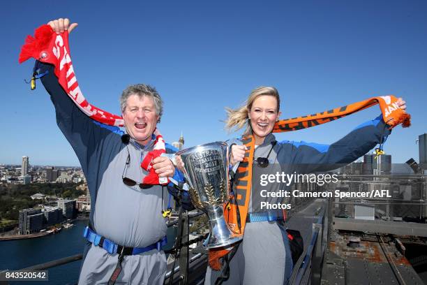 Giants fan Melissa Doyle and Sydney Swans fan Peter Phelps pose with the AFL Premiership Cup on top of the Sydney Harbour Bridge on September 7, 2017...