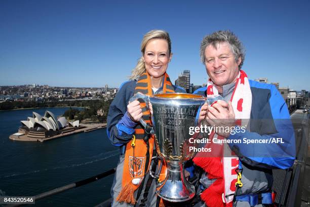 Giants fan Melissa Doyle and Sydney Swans fan Peter Phelps pose with the AFL Premiership Cup on top of the Sydney Harbour Bridge on September 7, 2017...