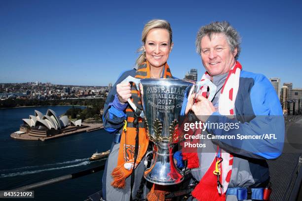 Giants fan Melissa Doyle and Sydney Swans fan Peter Phelps pose with the AFL Premiership Cup on top of the Sydney Harbour Bridge on September 7, 2017...