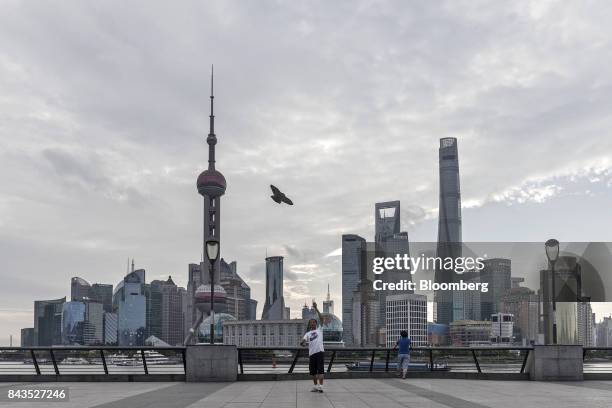 Man flies a kite along the bund as the Lujiazui Financial District stands in the background in Shanghai, China, on Monday, Sept. 4, 2017. The Chinese...