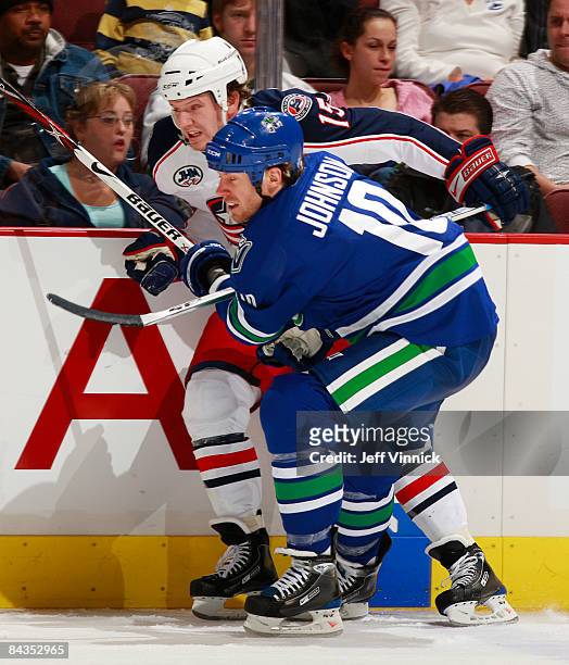 Ryan Johnson of the Vancouver Canucks and Jamie Langenbrunner of the New Jersey Devils battle along the boards during their game at General Motors...