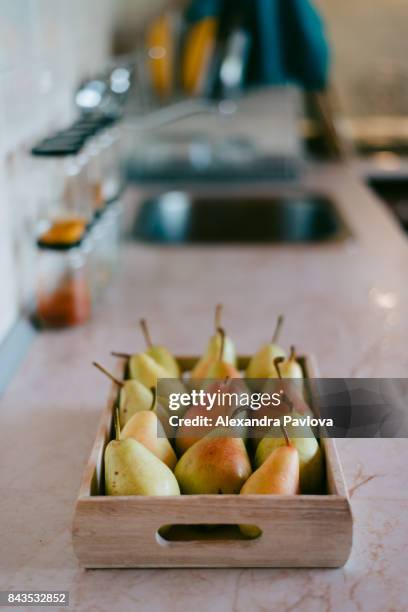 a crate of ripe pears in cozy kitchen interior - alexandra pavlova foto e immagini stock