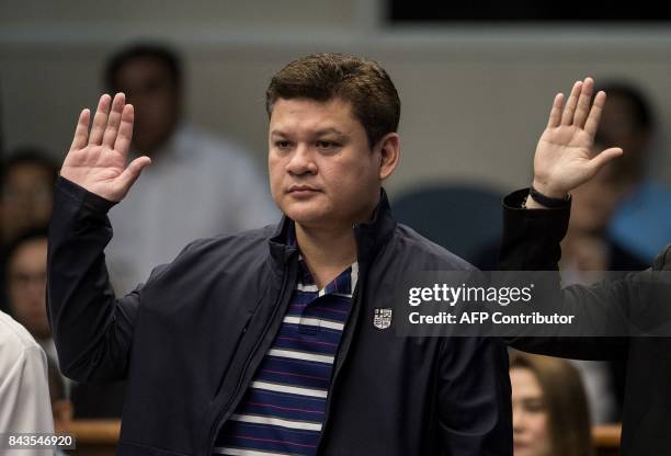 Davao City Vice Mayor Paolo Duterte, son of Philippine President Rodrigo Duterte, takes an oath as he attends a senate hearing in Manila on September...