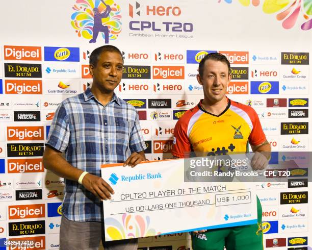 In this handout image provided by CPL T20, Luke Ronchi of Guyana Amazon Warriors receives the mana of the match cheque from Ian Leonard of Republic...