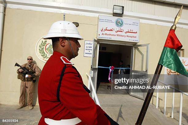 An Iraqi soldier and a US soldier stand guard during the inauguration ceremony for the Al-Muthana military hospital and centre for artificial limbs...