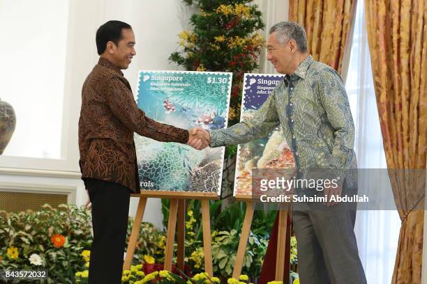 Indonesian President Joko Widodo and Singapore Prime Minister, Lee Hsien Loong shake hands after the unveiling the launch of the Joint Stamp Issue at...