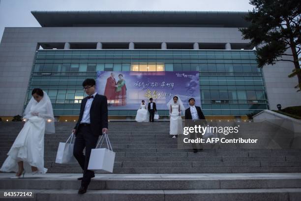 Couples leave a dormitory to take part in a mass wedding ceremony held by the unification church and entitled a 'cosmic blessing ceremony', in...