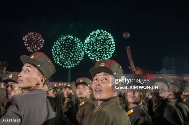 In a photo taken on September 6 Korean People's Army soldiers cheer while watching fireworks during a mass celebration in Pyongyang for scientists...