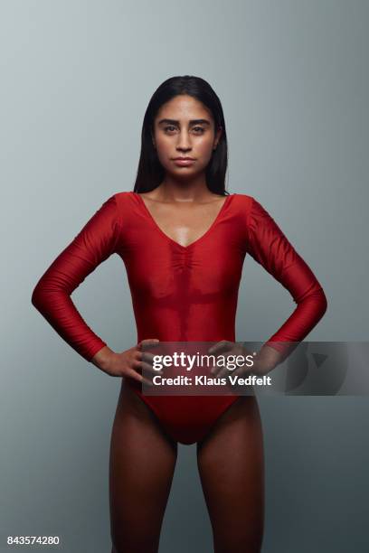 cool female gymnast looking in camera, wearing leotard - gymnastics poses stock-fotos und bilder