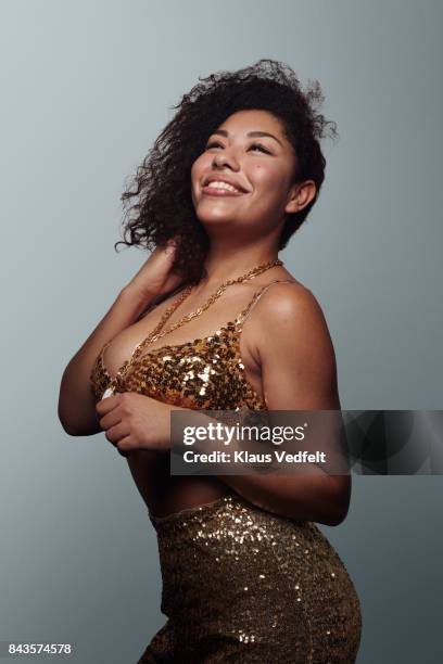 cool young woman wearing gold party clothes, looking up in the light and laughing - budding starlets stock pictures, royalty-free photos & images