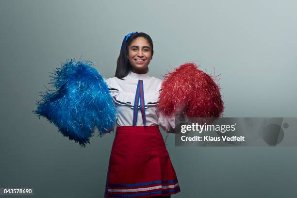 female cheerleader with pom poms, laughing to camera - pom pom stock-fotos und bilder
