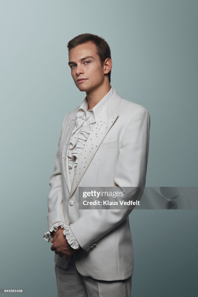 Young man wearing 70' white suit and puffy shirt