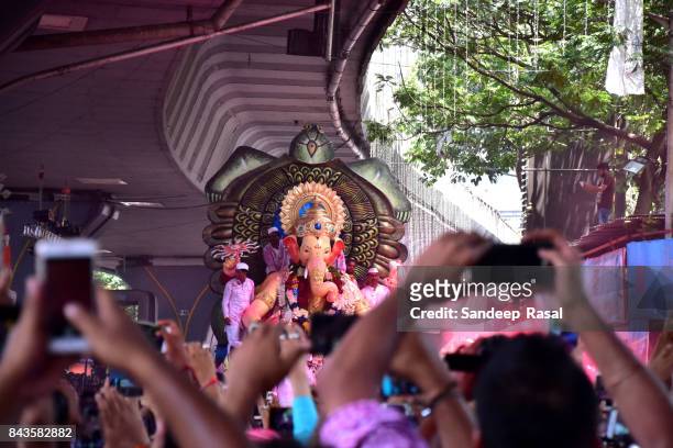 devotees taking pictures  in the procession with idol of the god ganesh - ganesh chaturthi fotografías e imágenes de stock