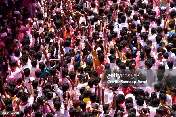 devotees in the procession with idol of the god ganesh - mumbai crowd stock pictures, royalty-free photos & images