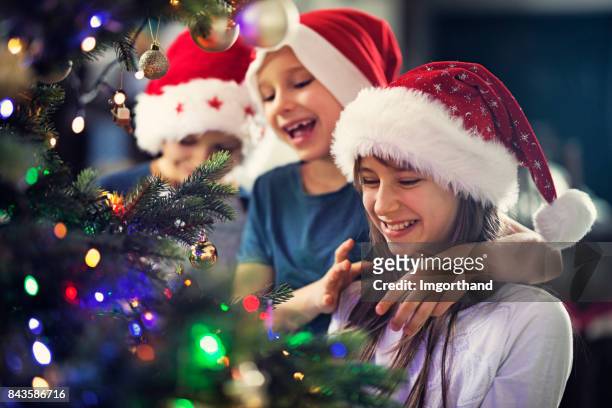 kids decorating christmas tree - kid with christmas tree stock pictures, royalty-free photos & images