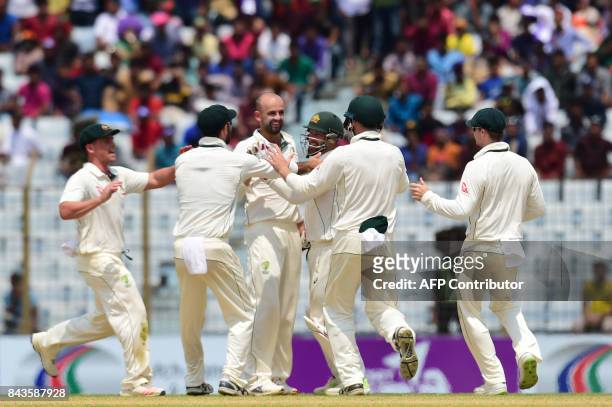 Australian cricketers congratulate teamamte Nathan Lyon after the dismissal of Bangladeshi cricketer Sabbir Rahman tries to makes his ground during...