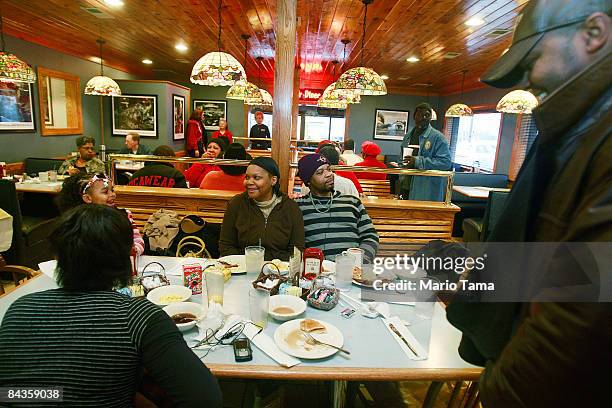 People who are riding a bus from Birmingham on the way to Washington, DC to attend the inauguration of President-elect Barack Obama have breakfast...