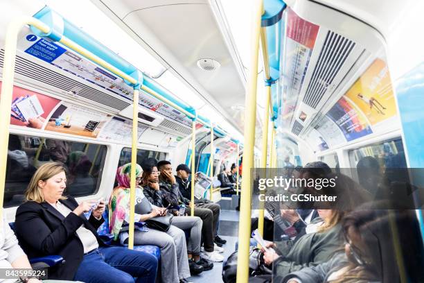 group of people patiently waiting in their seats for their station - underground sign stock pictures, royalty-free photos & images