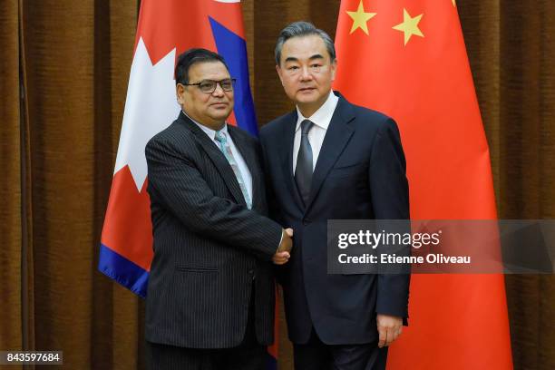 Deputy Prime Minister Of Nepal Krishna Bahadur Mahara shakes hands with Chinese Foreign Minister Wang Yi as he arrives for a meeting at the Ministry...