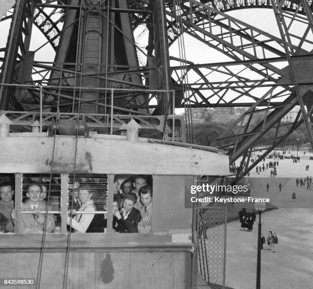 Vue de l'ascenseur de la Tour Eiffel rempli de visiteurs, à Paris, France en 1946.