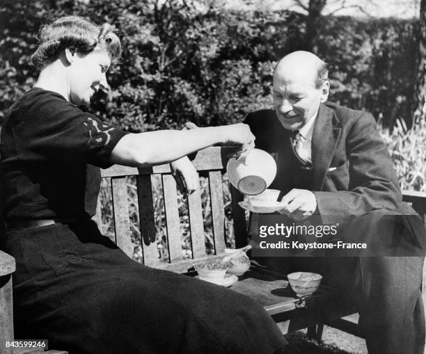 Le Premier Ministre britannique et sa femme Violet prennent le thé, coutume toute britannique, au soleil sur un banc, circa 1940 au Royaume-Uni.