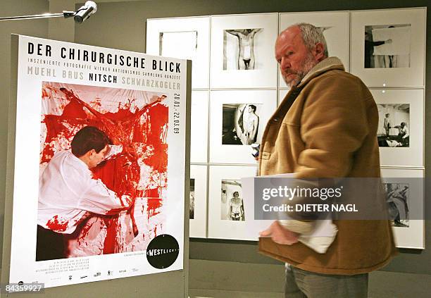 Visitor stands by a poster from action artist Hermann Nitsch during a press preview of a new exhibition "Der chirurgische Blick" about the Viennese...