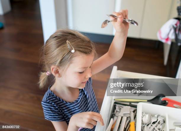 Bonn, Germany A five year old girl helps to cover the table and takes cutlery from a drawer on August 07, 2017 in Bonn, Germany.