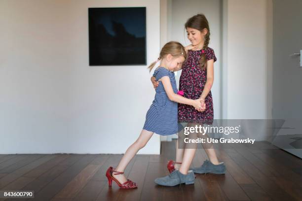 Bonn, Germany A five and a seven-year-old girl play up and dance tango in too big shoes on August 07, 2017 in Bonn, Germany.